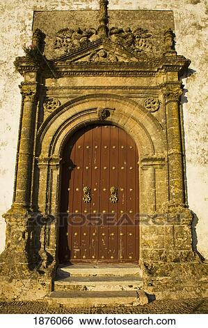 Stock Photograph - Medina Sidonia, Andalusia, Spain; The Wooden Door To The Iglesia Mayor With An Ornate Stone Frame. Fotosearch