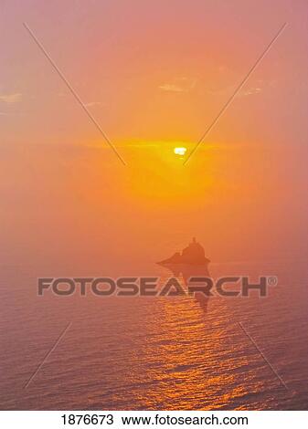 Stock Image - Oregon, United States Of America; Tillamook Rock Lighthouse And A Sunset Over The Pacific Ocean. Fotosearch