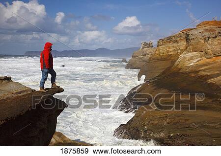 Pacific City, Oregon, United States Of America; A Man Standing On The Edge Of A Cliff Along The Coast At Cape Kiwanda View Large Photo Image Stock Photo - Pacific City, Oregon, United States Of America; A Man Standing On The Edge Of A Cliff Along The Coast At Cape Kiwanda. Fotosearch