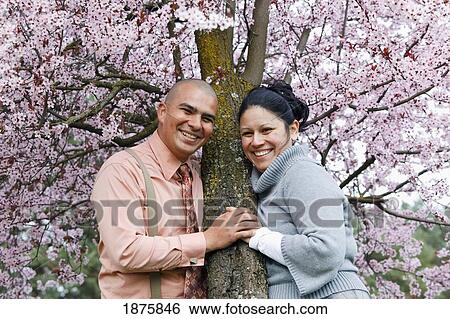 Stock Photograph - Portland, Oregon; A Couple By A Cherry Tree In Spring. Fotosearch