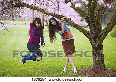 Portland, Oregon, United States Of America; Two Teenage Girls Hanging From A Tree Branch In Portland Park View Large Photo Image Picture - Portland, Oregon, United States Of America; Two Teenage Girls Hanging From A Tree Branch In Portland Park. Fotosearch