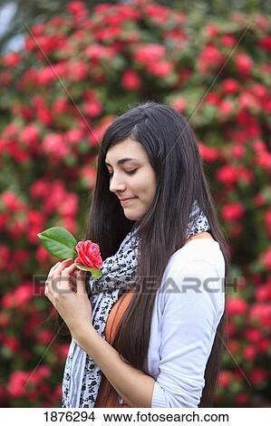Portland, Oregon, United States Of America; A Teenage Girl Holding A Flower By A Tree Full Of Blossoms In Portland Park View Large Photo Image Picture - Portland, Oregon, United States Of America; A Teenage Girl Holding A Flower By A Tree Full Of Blossoms In Portland Park. Fotosearch
