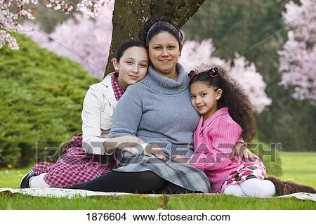 Picture - Portland, Oregon, United States Of America; A Mother And Her Two Daughters Under A Cherry Blossom Tree In Spring In Westmorland Park. Fotosearch