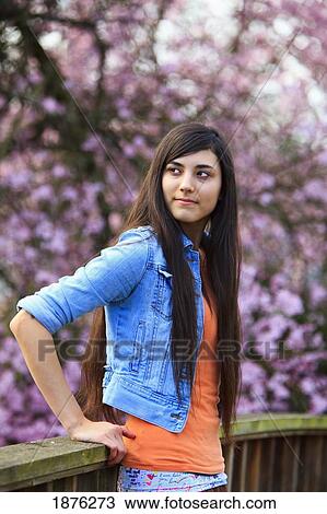 Stock Image - Portland, Oregon, United States Of America; A Teenage Girl Against A Wooden Railing In Portland Park. Fotosearch