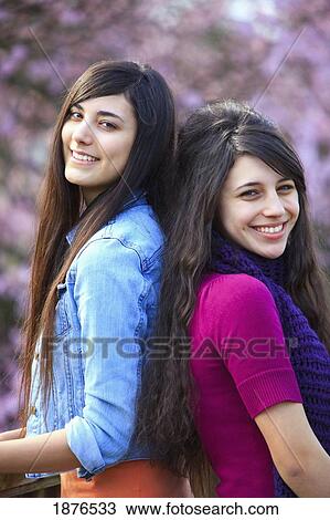 Stock Image - Portland, Oregon, United States Of America; Two Teenage Girls Standing In Portland Park. Fotosearch