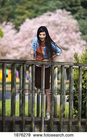 Portland, Oregon, United States Of America; A Teenage Girl Looking Down Over A Railing In Portland Park View Large Photo Image Stock Photo - Portland, Oregon, United States Of America; A Teenage Girl Looking Down Over A Railing In Portland Park. Fotosearch