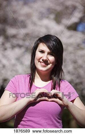 Portland, Oregon, United States Of America; A Teenage Girl Forming A Heart With Her Hands Over Her Chest View Large Photo Image Stock Photo - Portland, Oregon, United States Of America; A Teenage Girl Forming A Heart With Her Hands Over Her Chest. Fotosearch