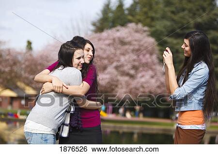 Stock Photograph - Portland, Oregon, United States Of America; Three Teenage Girls Using A Camera In Portland Park. Fotosearch