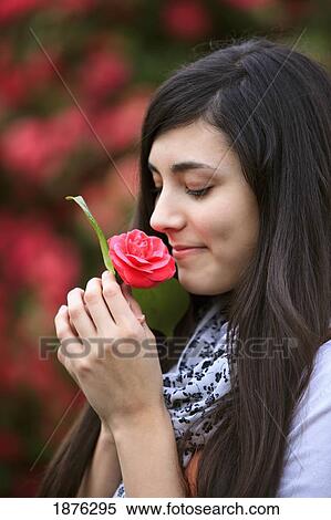 Stock Photography - Portland, Oregon, United States Of America; A Teenage Girl Smelling A Flower In Portland Park. Fotosearch