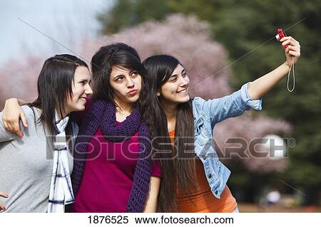 Stock Photography - Portland, Oregon, United States Of America; Three Teenage Girls Using A Camera And Being Silly In Portland Park. Fotosearch