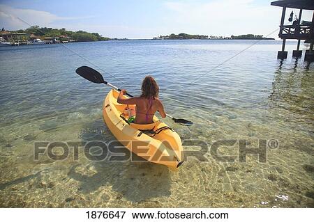 Stock Photo - Roatan, Bay Islands, Honduras; A Young Woman Paddling A Kayak At Anthony's Key Resort. Fotosearch