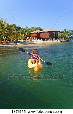 Stock Photography - Roatan, Bay Islands, Honduras; A Young Woman Paddling A Kayak At Anthony's Key Resort. Fotosearch
