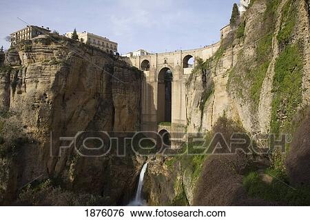 Stock Photograph - Ronda, Andalusia, Spain; The Bridge With A Waterfall And Rock Cliffs. Fotosearch