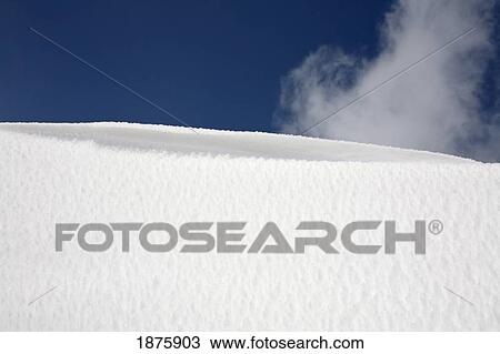 Stock Image - Whispy Cloud In A Blue Sky Over Snow. Fotosearch