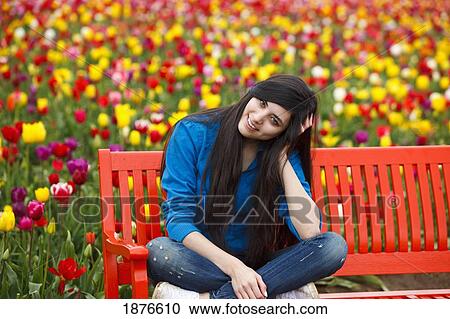 Woodburn, Oregon, United States Of America; A Teenage Girl Sits On A Red Bench In Front Of A Tulip Field At Wooden Shoe Tulip Farm View Large Photo Image Stock Image - Woodburn, Oregon, United States Of America; A Teenage Girl Sits On A Red Bench In Front Of A Tulip Field At Wooden Shoe Tulip Farm. Fotosearch