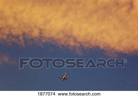 a commercial airliner in a cloudy sky View Large Photo Image Picture - a commercial airliner in a cloudy sky. Fotosearch