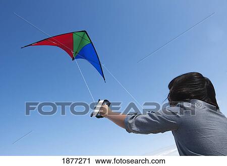Stock Image - a girl flying a kite. Fotosearch