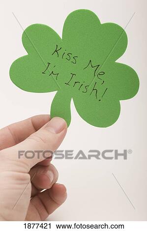 Stock Image - a hand holding a shamrock saying, 'kiss me, i'm irish'; edmonton, alberta, canada. Fotosearch