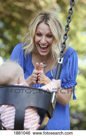 a mother playing with her baby in a swing; gresham, oregon, united states of america View Large Photo Image Stock Photograph - a mother playing with her baby in a swing; gresham, oregon, united states of america. Fotosearch