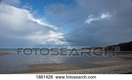 a rainbow in the distance over the water; normandy, france View Large Photo Image Stock Photo - a rainbow in the distance over the water; normandy, france. Fotosearch