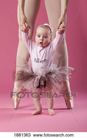 Stock Image - baby girl in tutu with ballerina in pointe shoes. Fotosearch