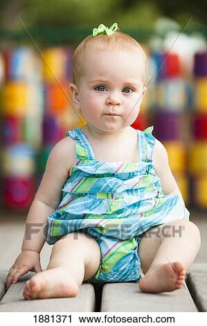 baby girl sitting on playground equipment View Large Photo Image Stock Image - baby girl sitting on playground equipment. Fotosearch