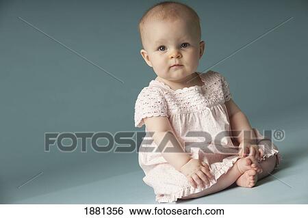 Stock Photograph - baby girl sitting with legs crossed. Fotosearch