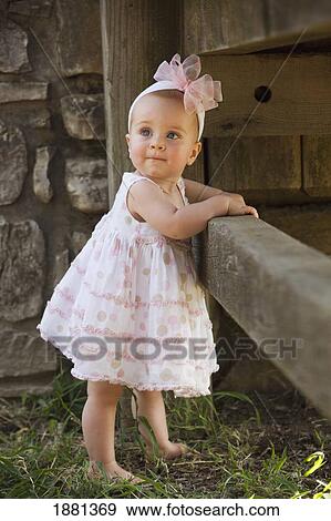 baby girl standing by a fence View Large Photo Image Stock Photo - baby girl standing by a fence. Fotosearch