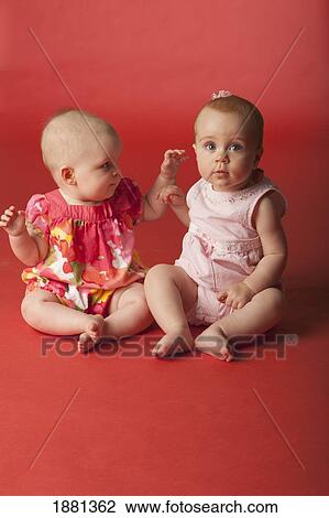 Stock Image - baby girls sitting together. Fotosearch