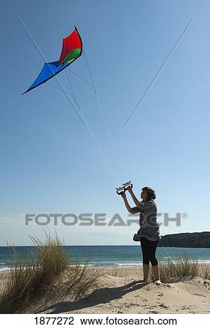 Stock Image - cadiz, andalusia, spain; a girl flying a kite on bolonia beach in costa de la luz. Fotosearch