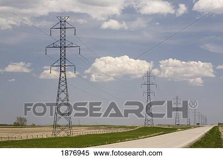 Stock Photography - calgary, alberta, canada; metal power lines in a row running along a road with a blue sky and clouds. Fotosearch