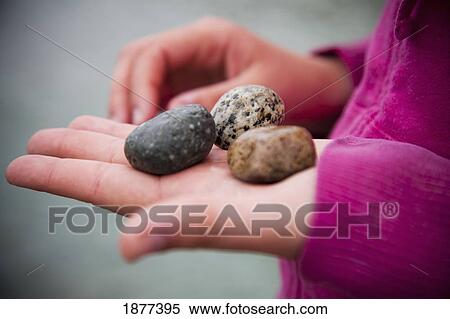 Stock Photography - different looking rocks held in a woman's hand. Fotosearch