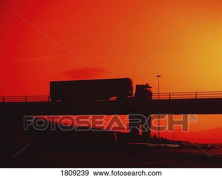 Dublin, Ireland; Truck Driving Over Bridge Silhouetted By Sunset View Large Photo Image Stock Photo - Dublin, Ireland; Truck Driving Over Bridge Silhouetted By Sunset. Fotosearch