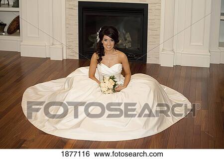 edmonton, alberta, canada; a bride sitting on the floor in front of a fireplace with her gown spread out around her View Large Photo Image Stock Photograph - edmonton, alberta, canada; a bride sitting on the floor in front of a fireplace with her gown spread out around her. Fotosearch