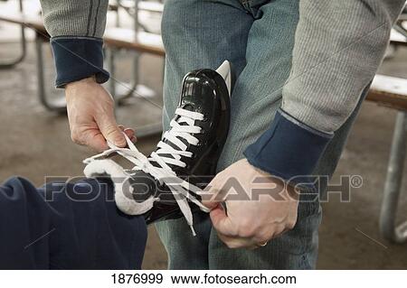 edmonton, alberta, canada; a father helping a son put on skates View Large Photo Image Stock Photo - edmonton, alberta, canada; a father helping a son put on skates. Fotosearch