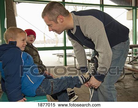 edmonton, alberta, canada; a father helping sons put on skates View Large Photo Image Stock Photography - edmonton, alberta, canada; a father helping sons put on skates. Fotosearch