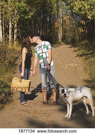 edmonton, alberta, canada; couple kissing on a path with their pet dog on their way to have a picnic View Large Photo Image Picture - edmonton, alberta, canada; couple kissing on a path with their pet dog on their way to have a picnic. Fotosearch