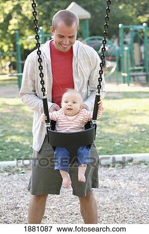 father pushing his young son on the swing; gresham, oregon, united states of america View Large Photo Image Stock Photo - father pushing his young son on the swing; gresham, oregon, united states of america. Fotosearch