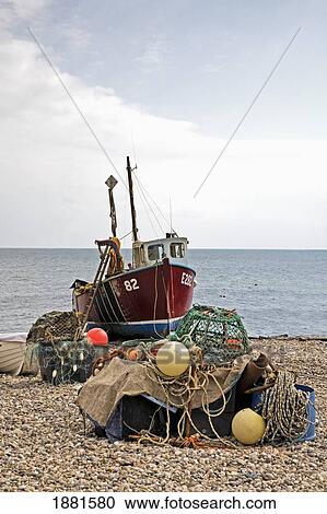 Stock Image - fishing boat and tackle on the beach; beer, devon, england. Fotosearch