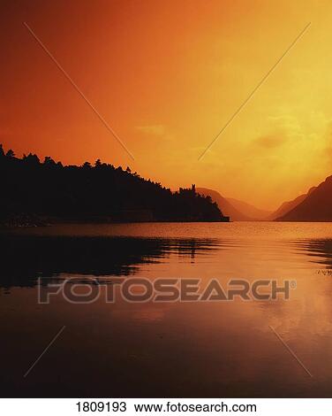 Glenveagh Castle, Co Donegal, Ireland; Sunset Over Lake With Castle Silhouetted In Background View Large Photo Image Stock Image - Glenveagh Castle, Co Donegal, Ireland; Sunset Over Lake With Castle Silhouetted In Background. Fotosearch