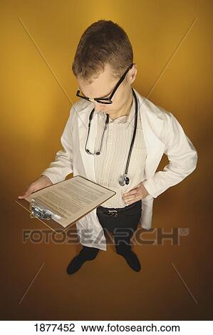 Stock Image - high angle of a doctor reading a document; edmonton, alberta, canada. Fotosearch