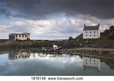 Stock Photo - houses along the water and a boat on the shore; st. abb's head, scottish borders, scotland. Fotosearch