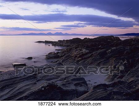 kintyre, argyll, scotland; sunset over the paps of jura from the rocky shores of the kintyre peninsula View Large Photo Image Picture - kintyre, argyll, scotland; sunset over the paps of jura from the rocky shores of the kintyre peninsula. Fotosearch
