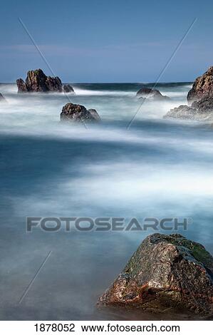 Stock Image - mist surrounding large rocks in the water; st. abb's head, northumberland, england. Fotosearch