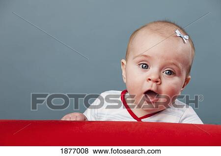 Stock Photo - nashville, tennessee, united states of america; a baby girl leaning on a red prop. Fotosearch