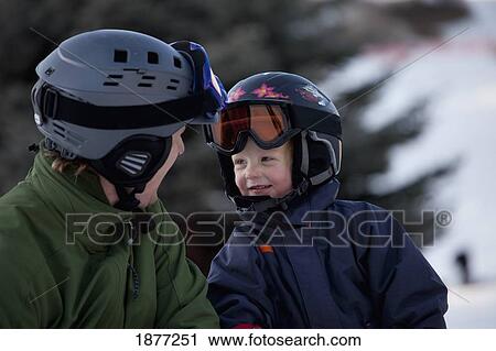 red deer, alberta, canada; a father and son wearing helmets and ski masks at a ski area View Large Photo Image Stock Image - red deer, alberta, canada; a father and son wearing helmets and ski masks at a ski area. Fotosearch