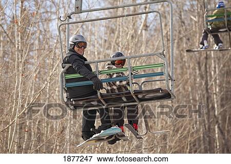red deer, alberta, canada; a father and son on a chair lift at a ski area View Large Photo Image Stock Photo - red deer, alberta, canada; a father and son on a chair lift at a ski area. Fotosearch