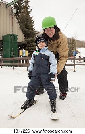 red deer, alberta, canada; a father and young son wearing helmets and skis at a ski area View Large Photo Image Stock Photograph - red deer, alberta, canada; a father and young son wearing helmets and skis at a ski area. Fotosearch