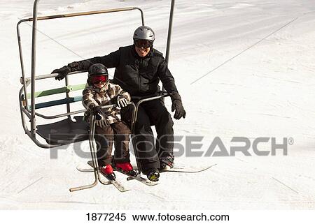 red deer, alberta, canada; a father and son on a chair lift at a ski area View Large Photo Image Stock Photography - red deer, alberta, canada; a father and son on a chair lift at a ski area. Fotosearch