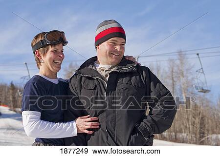 red deer, alberta, canada; a man and woman laughing together wearing a toque and ski mask at a ski area View Large Photo Image Stock Photo - red deer, alberta, canada; a man and woman laughing together wearing a toque and ski mask at a ski area. Fotosearch